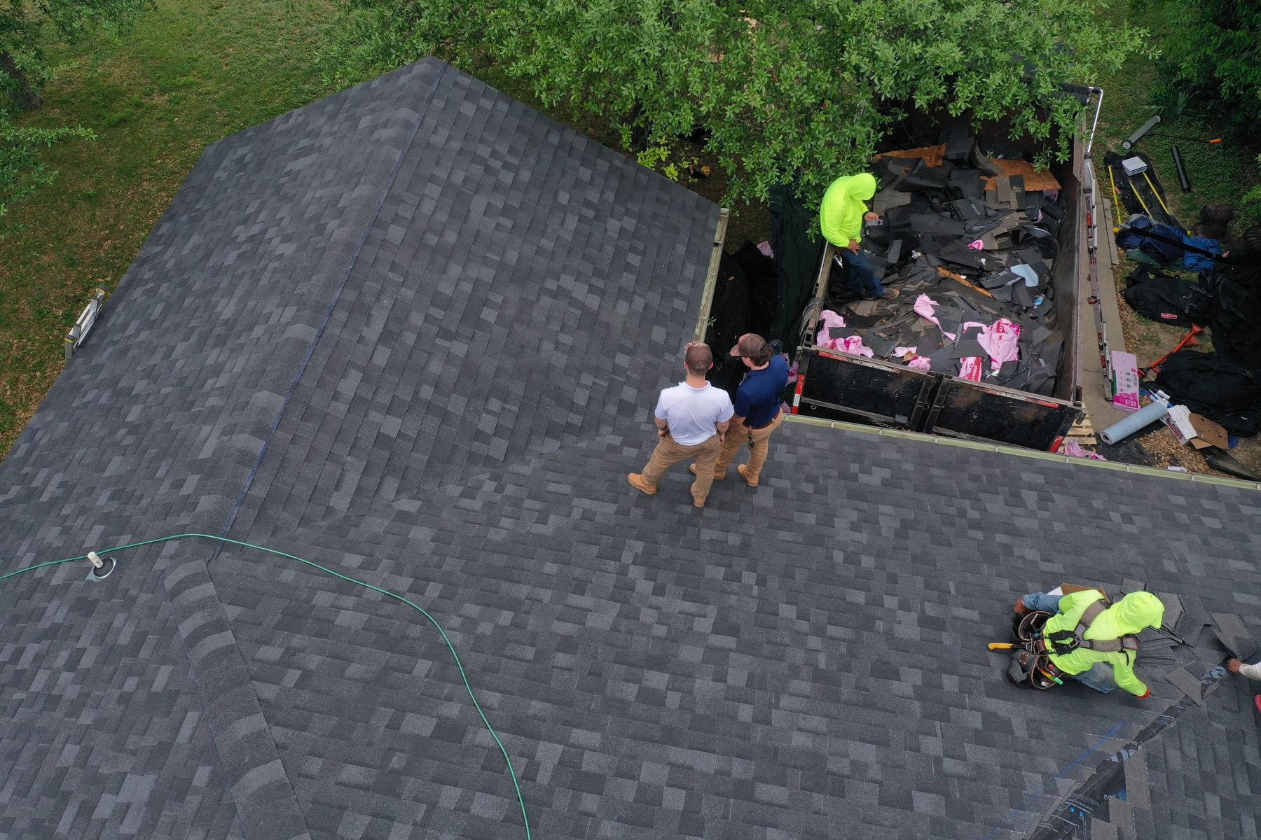 Crew carrying shingle bundles up the slope